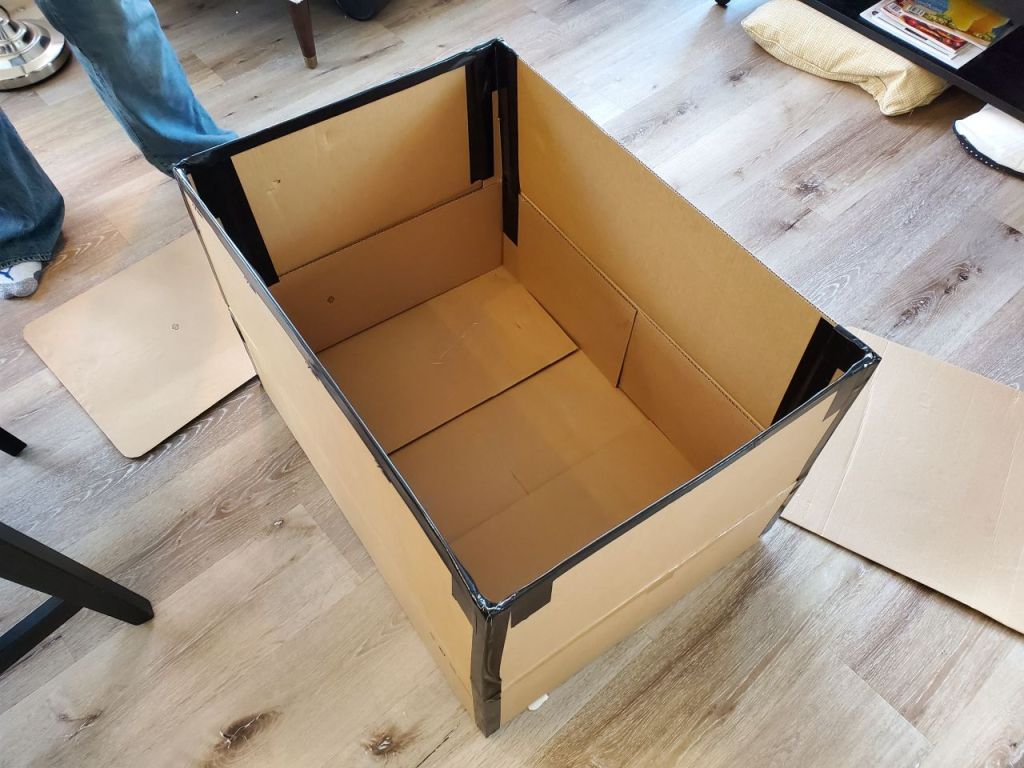 Cardboard box with extended walls with duct tape. 
