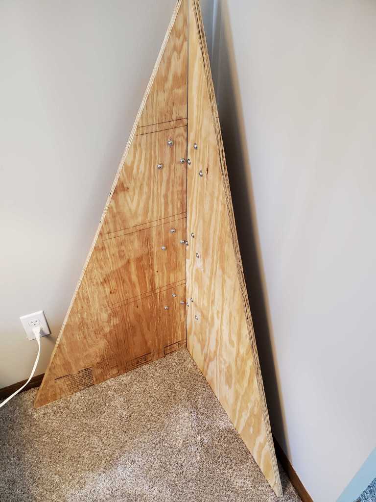 The two triangle plywood pieces connected to make a tree.