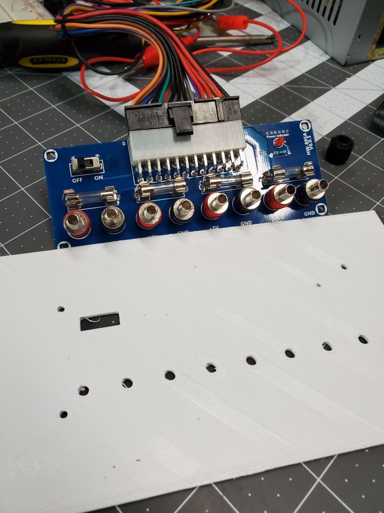 An ATX power supply breakout board with a 3d printed front cover that is too small.