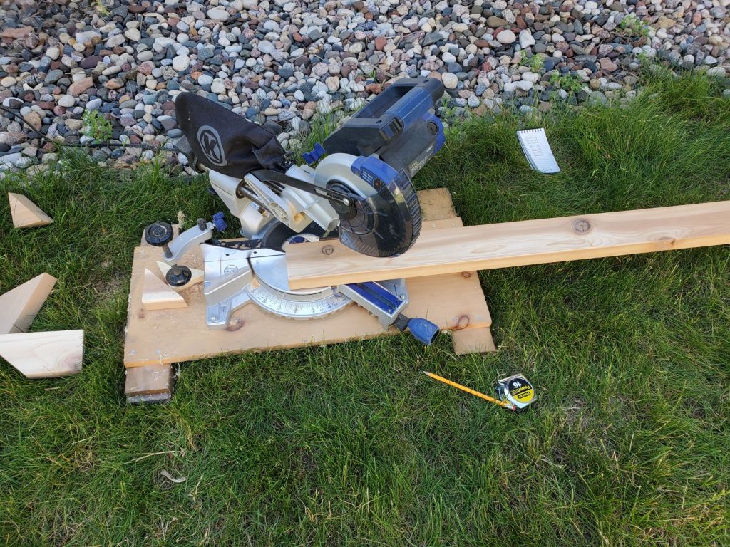 A miter saw cutting a cedar board.