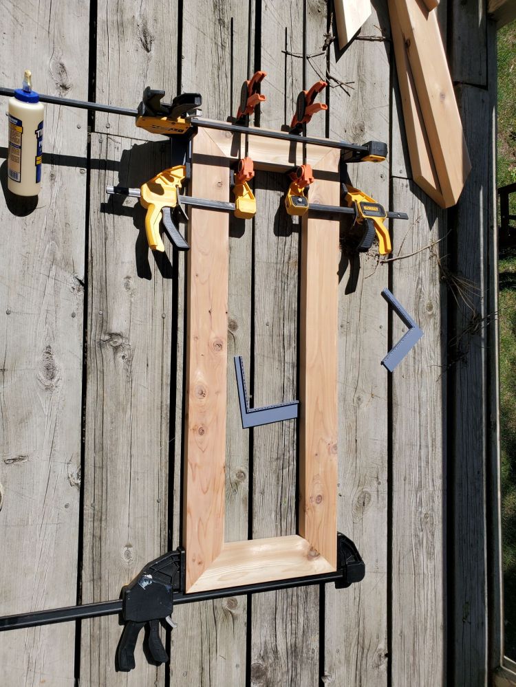 A cedar rectangle that is held together with clamps. 